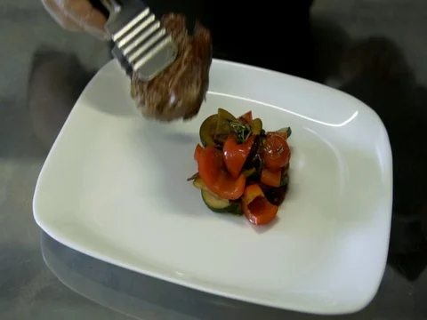 The chef puts a steak on a plate. slow motion 動画素材 76056176
