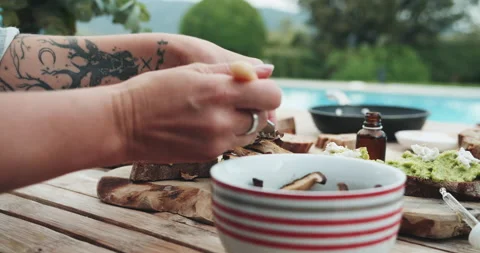 Chef puts sun-dried mushrooms to the dish on a wooden table at the summer Stock-Footage 144261853