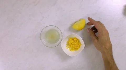 Chef puts on table lemon rind, squeezed lemon and lemon juice Stock Footage 99542975