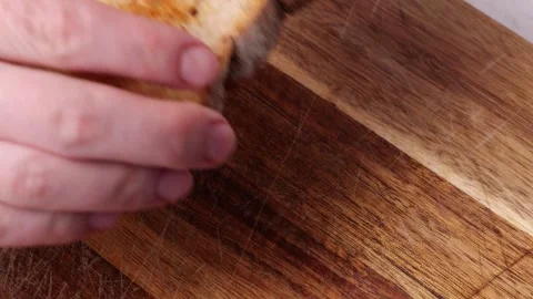 Chef puts toasted bread on a wooden cutting board in slow-motion Stock Footage 306415712