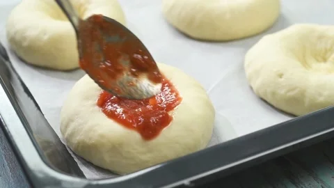 The chef puts tomato sauce on the mini pizza. Stock Footage 210718232