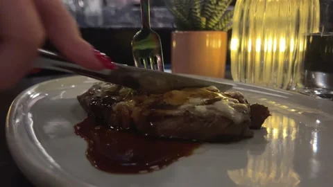A chef puts tomato sauce on pieces of steak that are turning on a fork against a Vídeo Stock 302270876