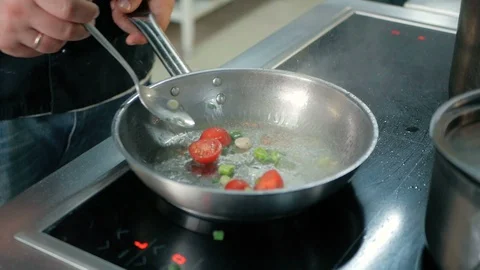 Chef puts the tomatoes in the pan in a restaurant kitchen. Stock Footage 92938125