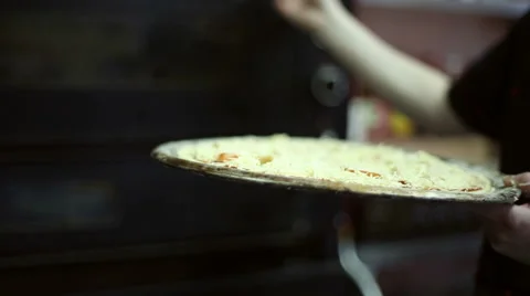 The chef puts the tray with the pizza into the oven Видео 59700196