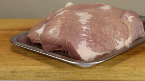Chef puts a tray with a raw pork Stock Footage 122119012