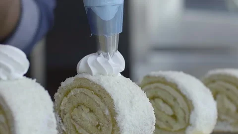 Chef puts whipped cream on a cake covered with shredded coconut Stock Footage 158120576