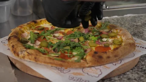 A chef putting arugula on pizza before serving in a traditional Italian pizzeria Video stock 344038670