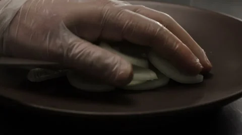 Chef putting chopped into half rings onion into the plate, close up Video stock 66062561