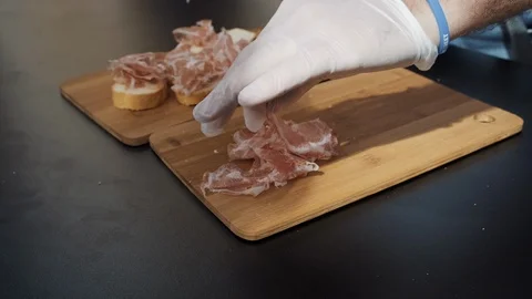 Chef is putting cut bacon on bread slices Stock Footage 115672469