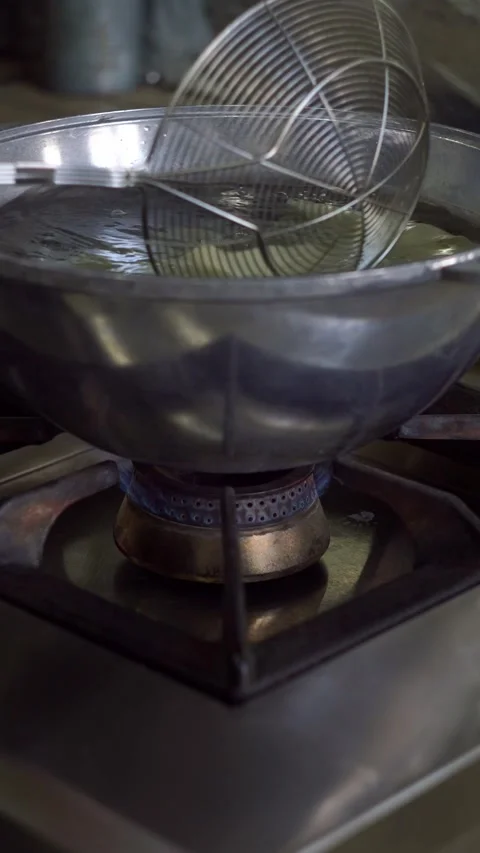 Chef putting fresh dough sheet into boiling water in a cauldron over gas stove b Stock Footage 342627967