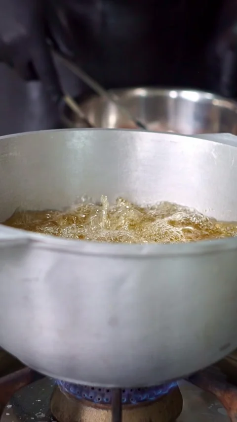 Chef putting fresh raw fish steak into hot boiling oil in a cauldron, close-up Stock Footage 342345268
