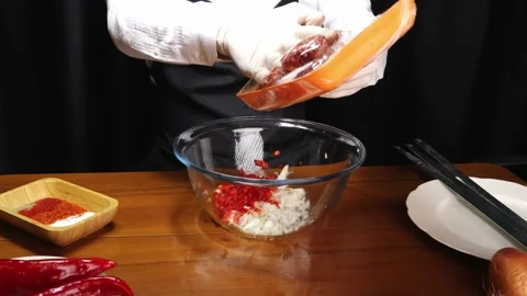 Chef is putting ground beef in glass bowl with onion and pepper 스톡 동영상 190070202