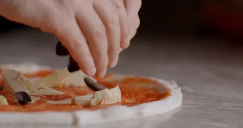 Chef putting ingredients on top of raw pizza Stock Footage 125607339
