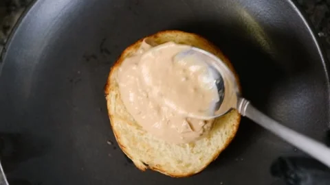 Chef putting sauce on a hamburger bun in black gloves slow motion Stock Footage 230076181