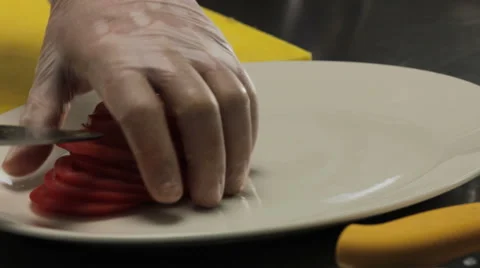 Chef putting sliced tomato on a plate Vidéo 66074807