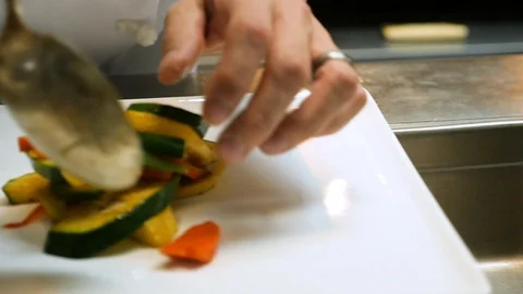 Chef putting vetegables on plates in kitchen Stock-Footage 94263533