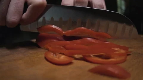 Chef quickly cuts red peppers on a wooden board Stock Footage 141187051