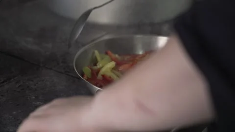 Chef quickly roasts bell peppers in a frying pan, close-up. Stock Footage 315423538