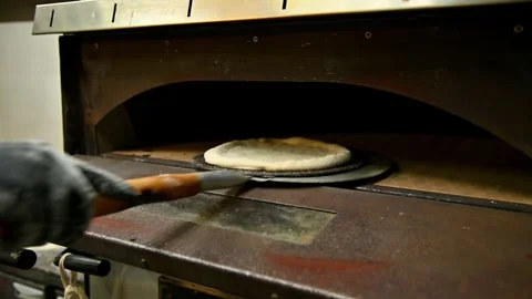 Chef removes baked bread from oven using paddle in commercial kitchen 库存影片 337229686