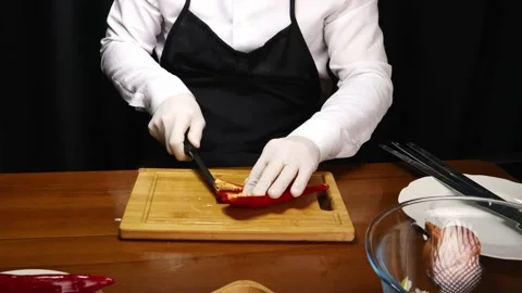 Chef removes seeds from red pepper with knife 스톡 동영상 190076672