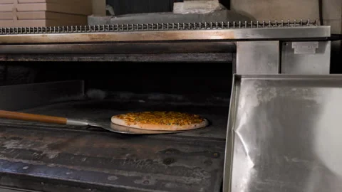 Chef Removing and Checking Pizza in Hot Oven 動画素材 303229881