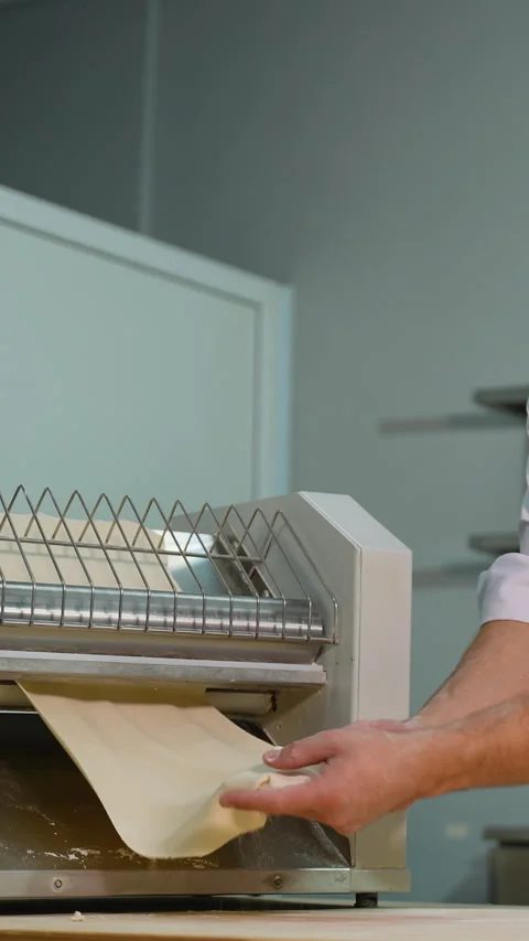 Chef Removing Flattened Dough from Sheeter Machine Stock Footage 299650757