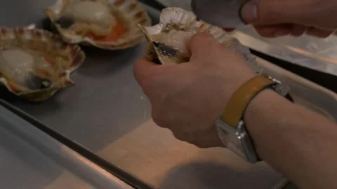 Chef removing fresh scallop meat from the shell Stockbeeldmateriaal 344300077