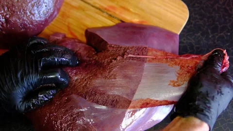 Chef removing thin membrane from fresh raw beef liver on wooden cutting board Stock Footage 346263229