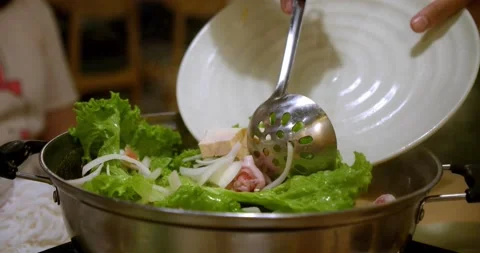 The chef in the restaurant at the client's table prepares soup, pours the Stock Footage 148718640