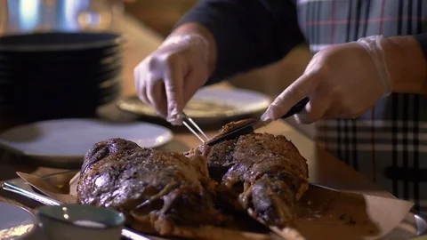 The chef in the restaurant cuts the finished dish and arranges it on plates. Stock-Footage 125057264