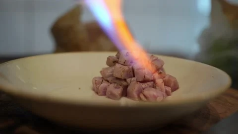 The chef in the restaurant kitchen fry chopped fish, tuna from a gas burner Stock Footage 141577078