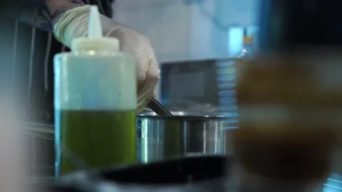 Chef in the restaurant kitchen with gloves pulls out pasta with tweezers Stock Footage 141307065
