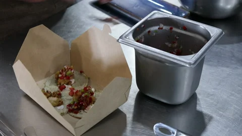 Chef in a restaurant kitchen preparing some tacos to take away. Takeaway. Video stock 221233670
