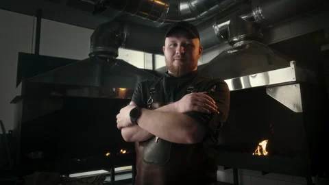 Chef of the restaurant kitchen stands with folded hands in the area where meat Stock Footage 314577082