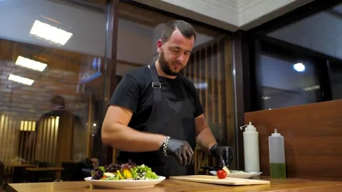 The chef in the restaurant prepares the dish for serving to the table Stock Footage 248055696