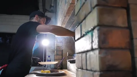 The chef in the restaurant puts the meat on the grill Stock Footage 248075599