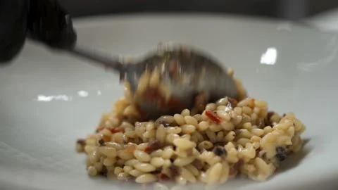 The chef in the restaurant puts a portion of rice in a white plate with a spoon Stock Footage 164559079