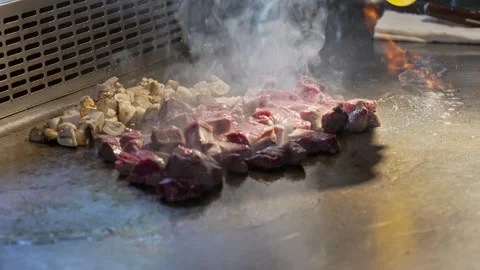 The chef of the restaurant roasts meat and mushrooms in a frying pan. We cook Stock Footage 279235059