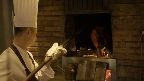 Chef Roasting Poultry Over Open Wood Fire in Traditional Beijing Restaurant Stock Footage 345782502