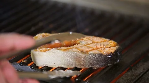 Chef roasting salmon steak on the grill slowmotion Stock Footage 58408107
