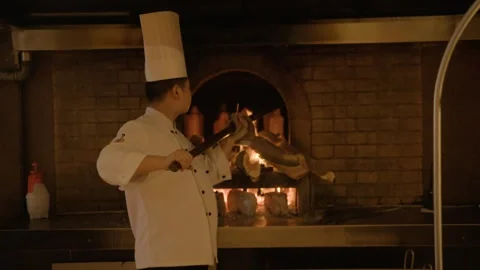 Chef Roasting Whole Poultry Over Wood Fire in Beijing Restaurant Kitchen Stock Footage 345786607