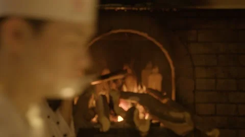 Chef Roasting Whole Poultry Over Open Wood Fire in Traditional Beijing Stock Footage 345786989