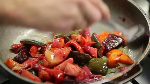 Chef roasts fresh vegetables in a pan with rosemary slowmotion Stock Footage 58407873