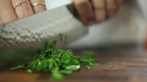 Chef rolling and cutting basil with a kitchen knife Stock Footage 59887694