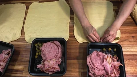 Chef rolling fresh bread dough with green olives and ham slices for homemad.. Stock Footage 337524188