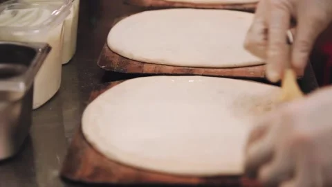 The chef is rolling out the dough in the restaurant kitchen. Stock Footage 134266333