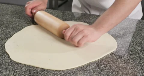 Chef rolling out pasta phyllo dough with a rolling pin. Close-up Stock Footage 286344920