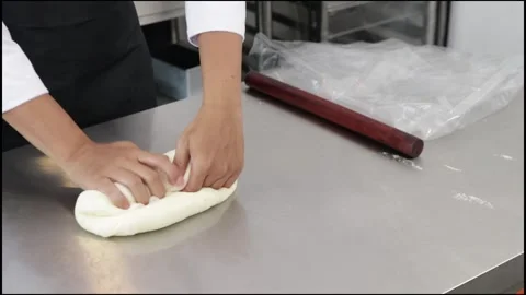 Chef rolling out white bread dough Stock Footage 296045585