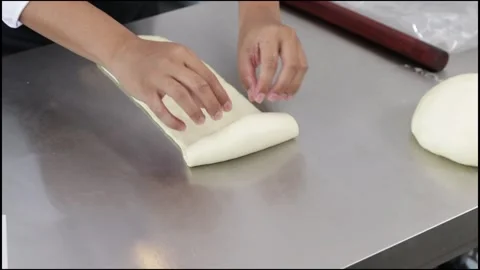 Chef rolling out white bread dough Stock Footage 296045702