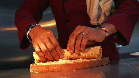 Chef rolling together a tortilla filled with chicken and vegetables Stock Footage 230080475